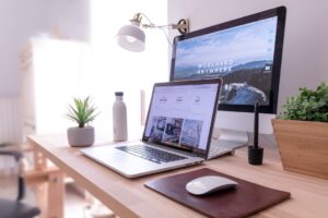 Macbook pro on table beside white imac and magic mouse hgv2tfoh0ns 300x200