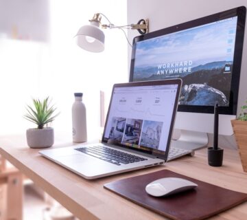 Macbook pro on table beside white imac and magic mouse hgv2tfoh0ns 360x320